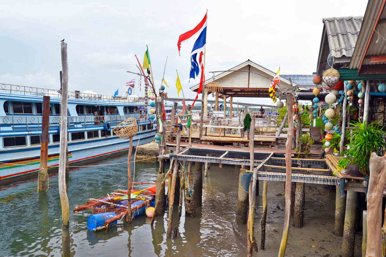 a boat is docked at a pier with flags on it